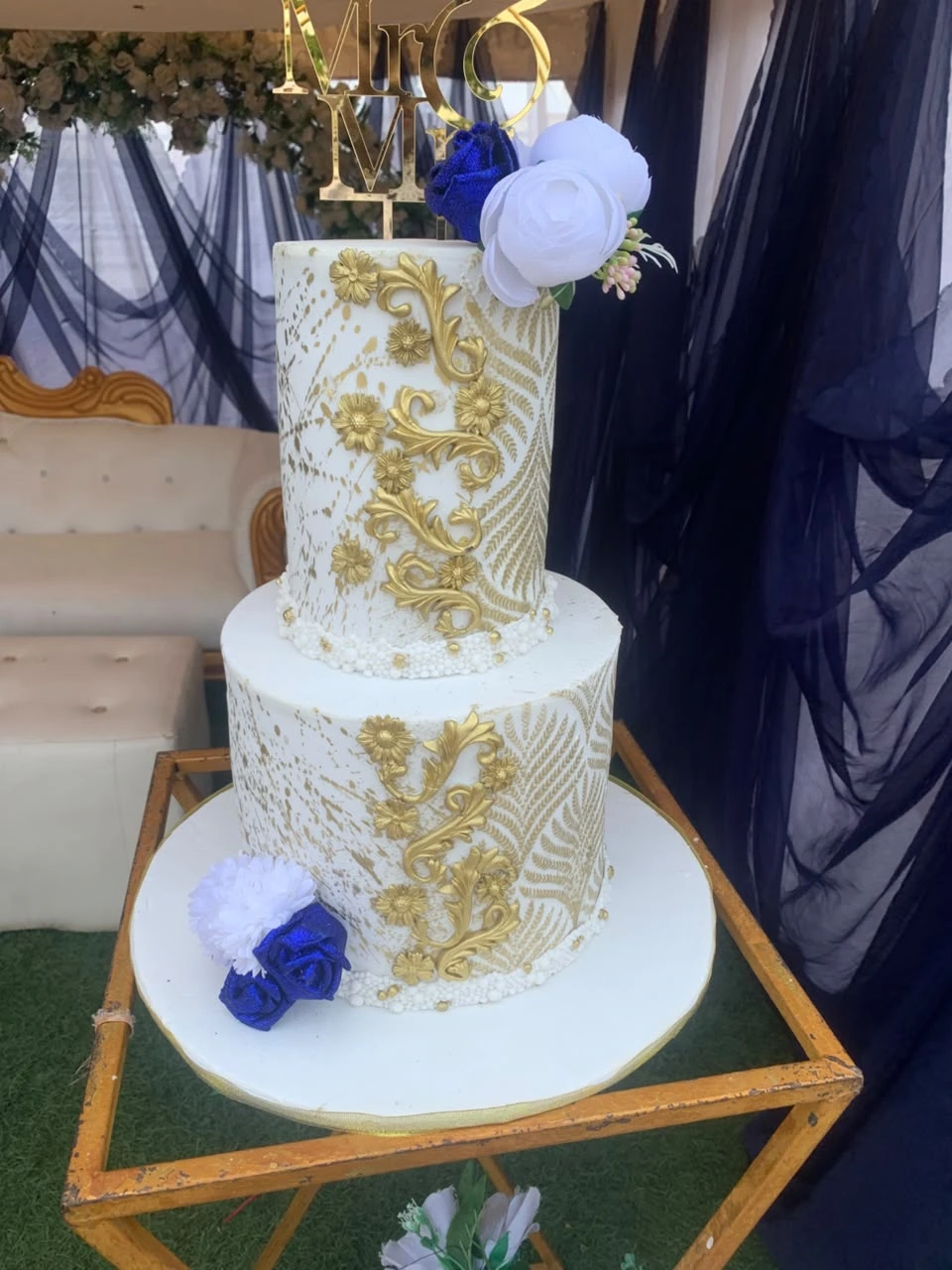 Luxury 2-tier celebration cake with golden drip frosting and fresh flowers