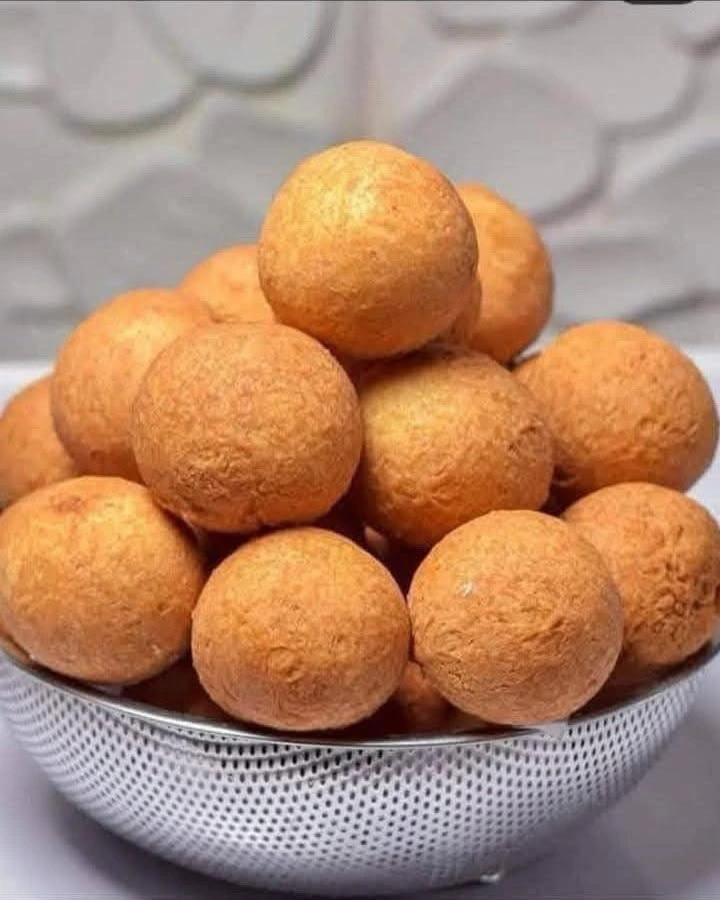 Freshly prepared Nigerian small chops assortment: puff puff, samosa, spring rolls, sausage rolls